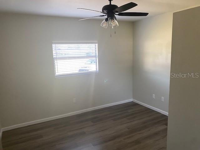 1750 Mitten Ter, Deltona, FL 32738 - spare room featuring dark wood-type flooring, a ceiling fan, and baseboards