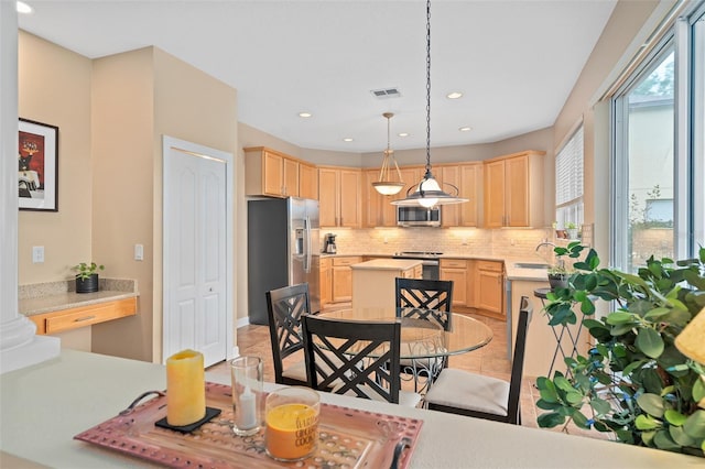 490 Wekiva Preserve Dr, Apopka, FL 32712 - kitchen with appliances with stainless steel finishes, light brown cabinetry, decorative backsplash, light countertops, and a center island
