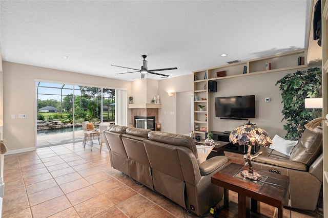 490 Wekiva Preserve Dr, Apopka, FL 32712 - living area featuring ceiling fan, a tile fireplace, a textured ceiling, light tile patterned flooring, and recessed lighting