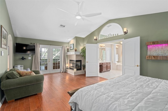 490 Wekiva Preserve Dr, Apopka, FL 32712 - bedroom featuring french doors, access to exterior, wood finished floors, a tiled fireplace, and high vaulted ceiling