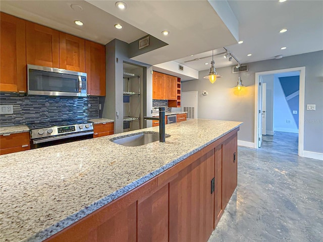 3034 Parkway Blvd Unit 102, Kissimmee, FL 34747 - kitchen with appliances with stainless steel finishes, a sink, baseboards, backsplash, and brown cabinetry