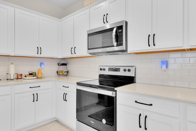 1425 Lone Wood Blvd, Orlando, FL 32828 - kitchen with stainless steel appliances, white cabinetry, light countertops, and backsplash