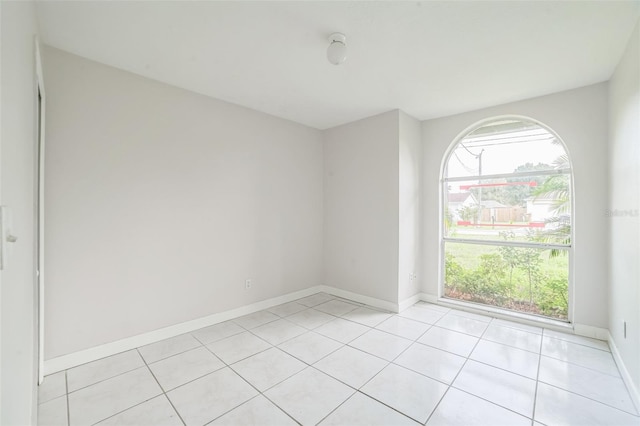657 Mckinley Ct, Kissimmee, FL 34758 - empty room with light tile patterned flooring, plenty of natural light, and baseboards