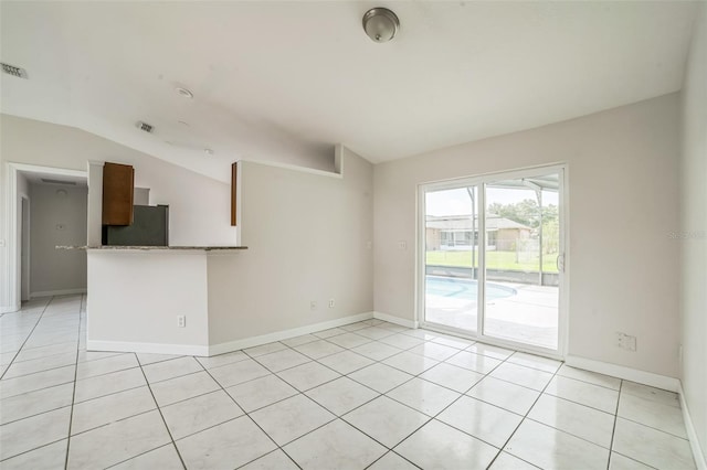 657 Mckinley Ct, Kissimmee, FL 34758 - spare room featuring vaulted ceiling, light tile patterned floors, and baseboards