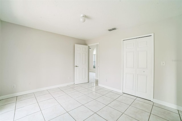 657 Mckinley Ct, Kissimmee, FL 34758 - unfurnished bedroom featuring light tile patterned floors, a closet, and baseboards
