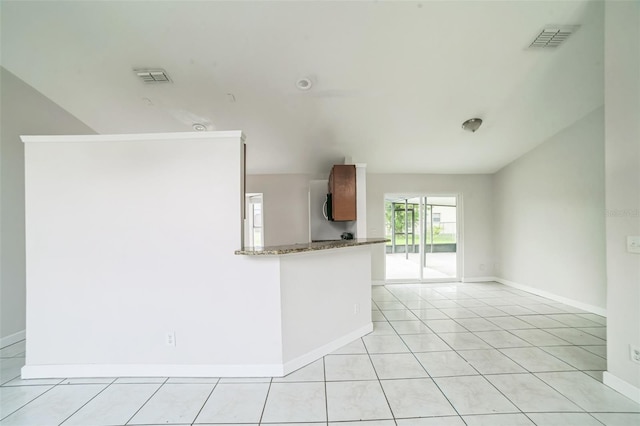 657 Mckinley Ct, Kissimmee, FL 34758 - kitchen featuring baseboards, light tile patterned flooring, and dark stone counters