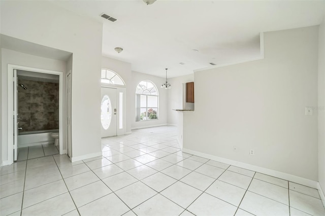 657 Mckinley Ct, Kissimmee, FL 34758 - unfurnished room with light tile patterned floors, baseboards, and a chandelier