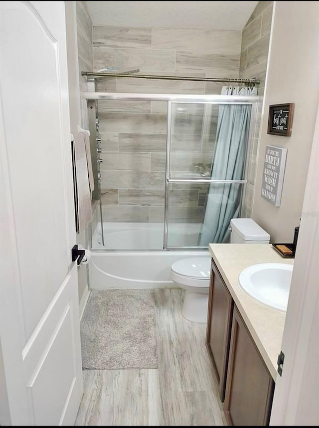 725 Ashworth Overlook Dr Unit C, Apopka, FL 32712 - bathroom featuring vanity, toilet, bath / shower combo with glass door, and wood finished floors