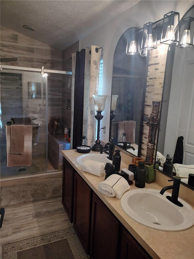 725 Ashworth Overlook Dr Unit C, Apopka, FL 32712 - full bath with vaulted ceiling, a shower stall, double vanity, a textured ceiling, and wood finished floors