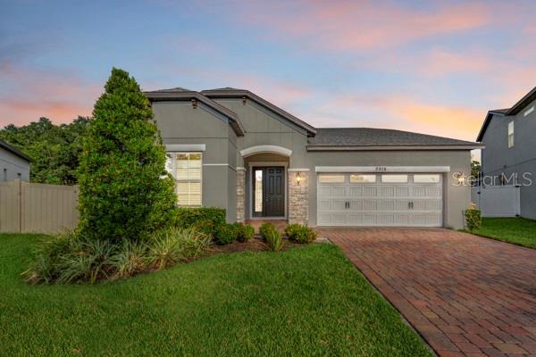 2914 Scarlett Dr, Saint Cloud, FL 34772 - view of front of house featuring decorative driveway, a garage, and stucco siding