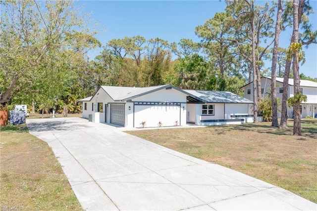 single story home with concrete driveway, an attached garage, and a front yard