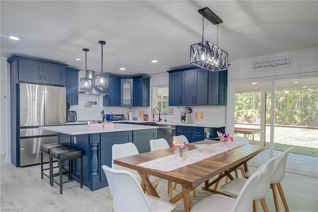 kitchen with stainless steel appliances, blue cabinets, tasteful backsplash, light countertops, and recessed lighting