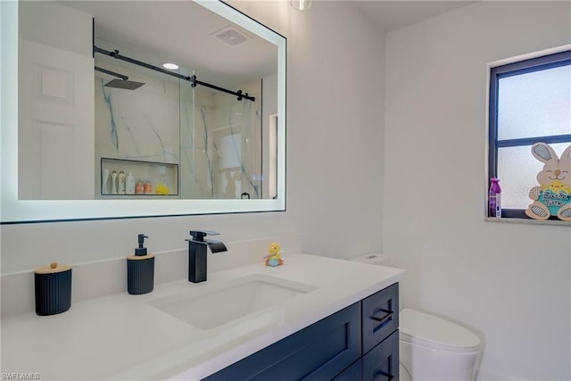 bathroom featuring a marble finish shower, vanity, and toilet