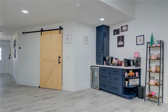 interior space featuring a barn door, wine cooler, light wood-type flooring, and recessed lighting