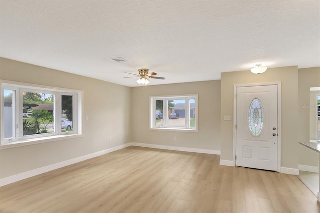 2835 Bongart Rd, Winter Park, FL 32792 - foyer entrance with healthy amount of natural light, light wood-type flooring, a ceiling fan, baseboards, and a textured ceiling
