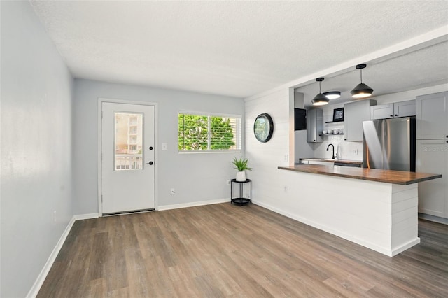 320 Lakeview St Unit 220, Orlando, FL 32804 - kitchen with freestanding refrigerator, butcher block counters, dark wood-type flooring, baseboards, and a textured ceiling