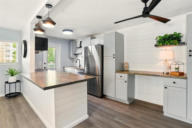 320 Lakeview St Unit 220, Orlando, FL 32804 - kitchen with stainless steel appliances, butcher block counters, a textured ceiling, dark wood-style flooring, and a peninsula
