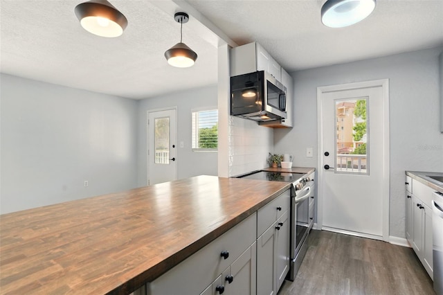 320 Lakeview St Unit 220, Orlando, FL 32804 - kitchen with butcher block countertops, appliances with stainless steel finishes, dark wood-type flooring, and white cabinetry