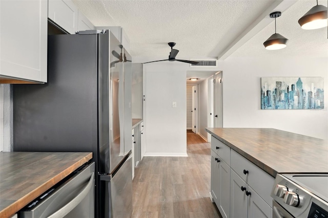 320 Lakeview St Unit 220, Orlando, FL 32804 - kitchen with appliances with stainless steel finishes, butcher block counters, a ceiling fan, light wood finished floors, and a textured ceiling