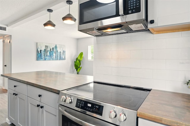 320 Lakeview St Unit 220, Orlando, FL 32804 - kitchen featuring stainless steel appliances, decorative backsplash, hanging light fixtures, white cabinets, and a textured ceiling