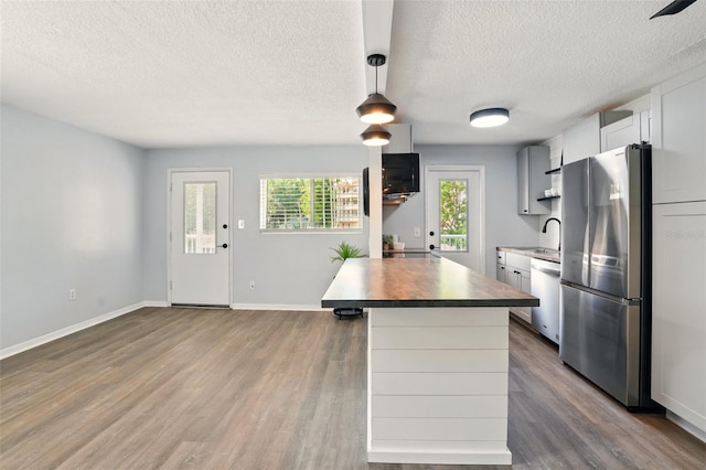 320 Lakeview St Unit 220, Orlando, FL 32804 - kitchen with appliances with stainless steel finishes, open shelves, a textured ceiling, wood finished floors, and baseboards