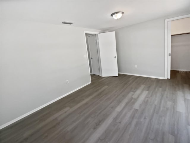 7604 Tyson Dr, Port Richey, FL 34668 - unfurnished bedroom with baseboards, dark wood-style flooring, a spacious closet, and a closet