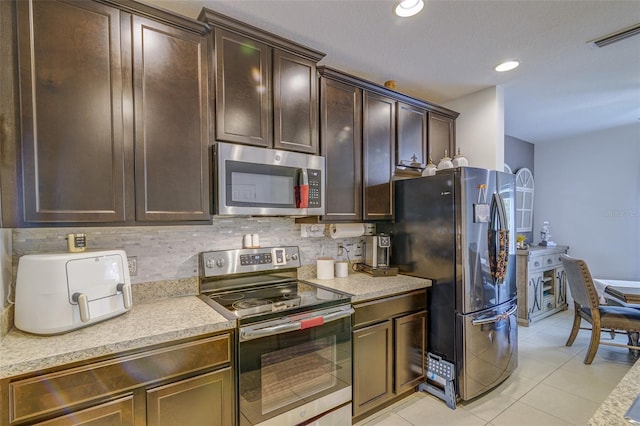 322 Annabelle Way, Davenport, FL 33837 - kitchen with appliances with stainless steel finishes, tasteful backsplash, light countertops, dark brown cabinetry, and recessed lighting