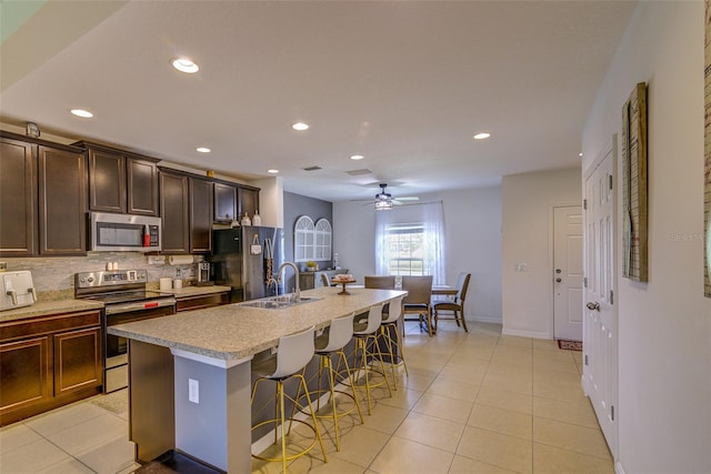 322 Annabelle Way, Davenport, FL 33837 - kitchen featuring appliances with stainless steel finishes, a kitchen breakfast bar, backsplash, a kitchen island with sink, and recessed lighting