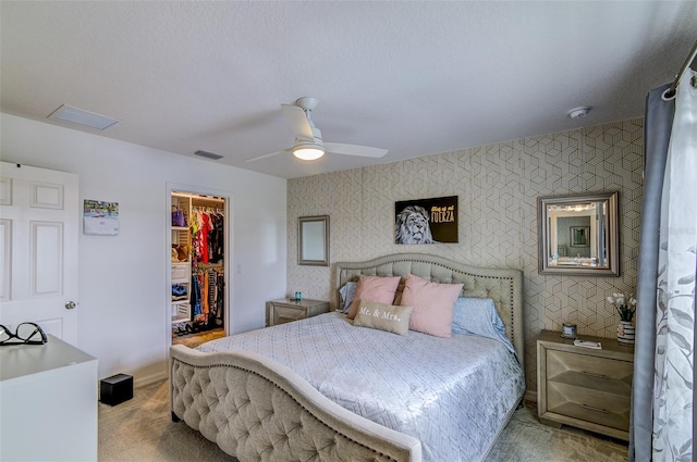 322 Annabelle Way, Davenport, FL 33837 - bedroom featuring an accent wall, wallpapered walls, a spacious closet, carpet flooring, and a closet