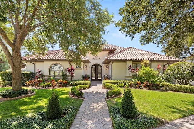 1010 Juliette Blvd, Mount Dora, FL 32757 - mediterranean / spanish house featuring french doors, a tile roof, stucco siding, and a front yard