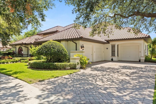 1010 Juliette Blvd, Mount Dora, FL 32757 - mediterranean / spanish-style home with a garage, stucco siding, decorative driveway, and a tile roof