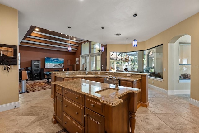 1010 Juliette Blvd, Mount Dora, FL 32757 - kitchen with a spacious island, brown cabinetry, a sink, and arched walkways