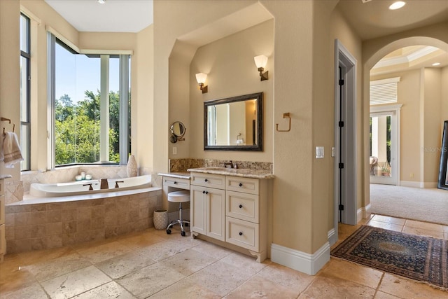 1010 Juliette Blvd, Mount Dora, FL 32757 - bathroom with stone tile floors, vanity, a bath, and baseboards