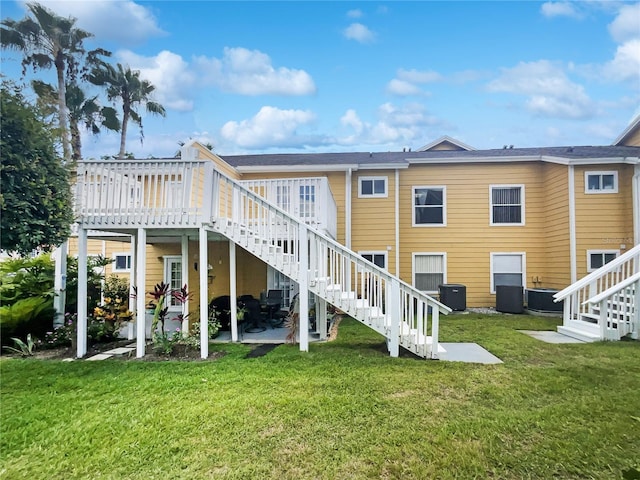 3142 Britannia Blvd Unit C, Kissimmee, FL 34747 - back of property with stairway, a patio area, a lawn, a deck, and central AC unit