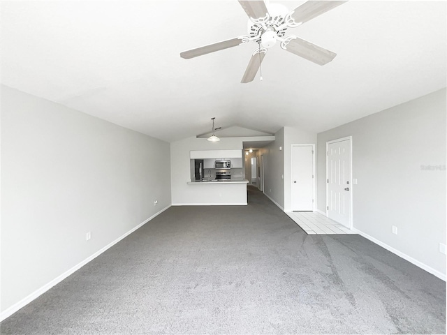 3142 Britannia Blvd Unit C, Kissimmee, FL 34747 - unfurnished living room with dark colored carpet, baseboards, vaulted ceiling, and a ceiling fan