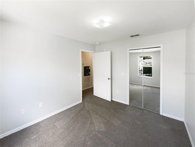 3142 Britannia Blvd Unit C, Kissimmee, FL 34747 - unfurnished bedroom featuring baseboards, a closet, and dark carpet