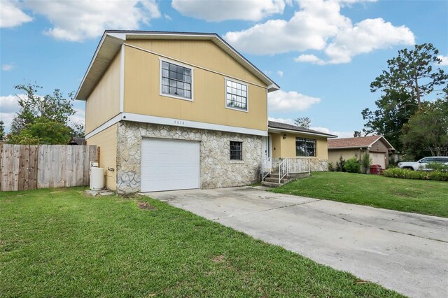 8652 Savory Dr, Orlando, FL 32825 - split level home with stone siding, a garage, and driveway