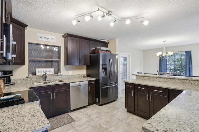 8652 Savory Dr, Orlando, FL 32825 - kitchen featuring appliances with stainless steel finishes, a sink, a chandelier, dark brown cabinets, and light tile patterned floors