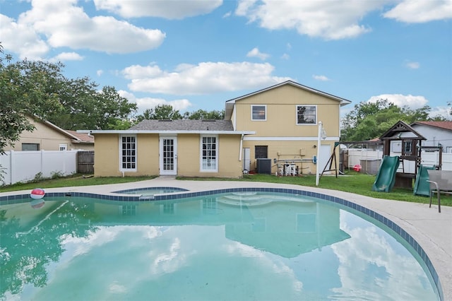 8652 Savory Dr, Orlando, FL 32825 - view of swimming pool featuring an in-ground hot tub, a playground, and central air condition unit