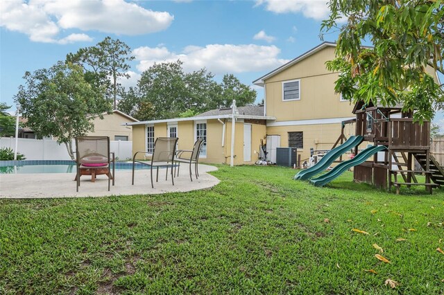 8652 Savory Dr, Orlando, FL 32825 - back of property with a playground, central AC, and a patio area
