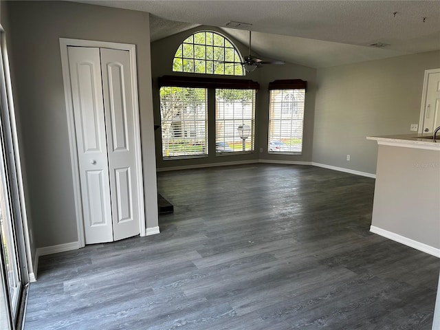 652 Roaring Dr Unit 234, Altamonte Springs, FL 32714 - unfurnished dining area featuring a ceiling fan, vaulted ceiling, baseboards, dark wood-type flooring, and a textured ceiling