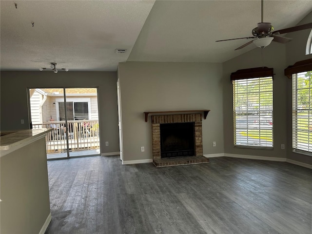 652 Roaring Dr Unit 234, Altamonte Springs, FL 32714 - unfurnished living room with a textured ceiling, dark wood-type flooring, ceiling fan, a brick fireplace, and lofted ceiling