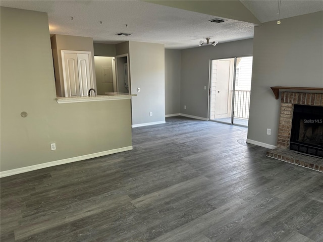 652 Roaring Dr Unit 234, Altamonte Springs, FL 32714 - unfurnished living room featuring baseboards, dark wood-style flooring, a textured ceiling, and a fireplace