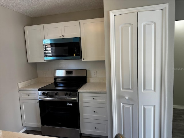 652 Roaring Dr Unit 234, Altamonte Springs, FL 32714 - kitchen featuring stainless steel appliances, tasteful backsplash, white cabinets, baseboards, and a textured ceiling