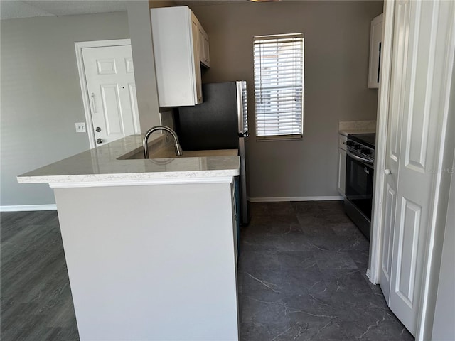 652 Roaring Dr Unit 234, Altamonte Springs, FL 32714 - kitchen featuring black range with electric stovetop, freestanding refrigerator, a sink, a peninsula, and baseboards