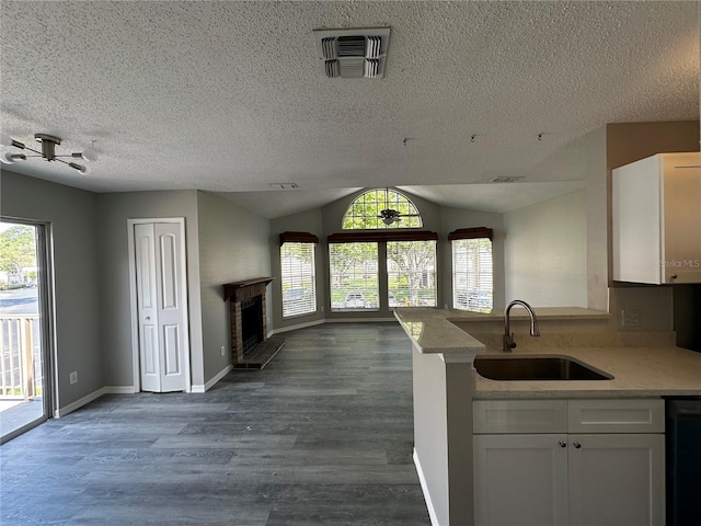 652 Roaring Dr Unit 234, Altamonte Springs, FL 32714 - kitchen with a sink, open floor plan, white cabinetry, light countertops, and a fireplace with raised hearth