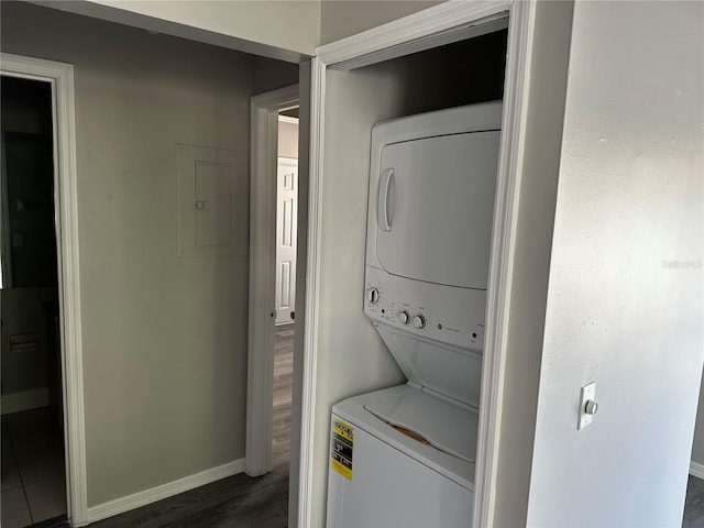 652 Roaring Dr Unit 234, Altamonte Springs, FL 32714 - washroom with stacked washer and clothes dryer, electric panel, baseboards, and dark wood-type flooring