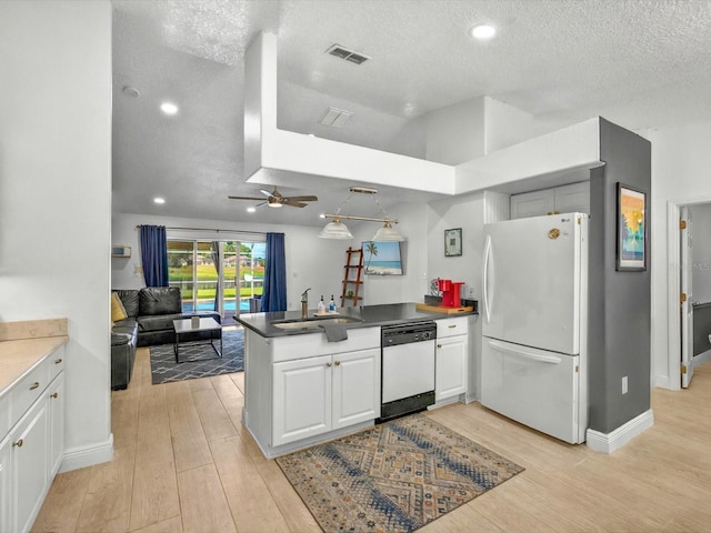 703 Sunridge Woods Blvd, Davenport, FL 33837 - kitchen featuring white appliances, a peninsula, light wood finished floors, a ceiling fan, and a textured ceiling