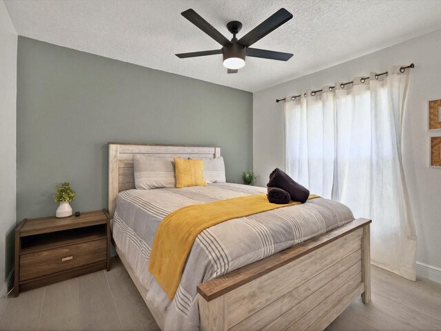 703 Sunridge Woods Blvd, Davenport, FL 33837 - bedroom featuring a textured ceiling, baseboards, ceiling fan, and wood finished floors