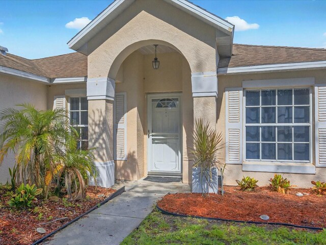 703 Sunridge Woods Blvd, Davenport, FL 33837 - property entrance with stucco siding and roof with shingles